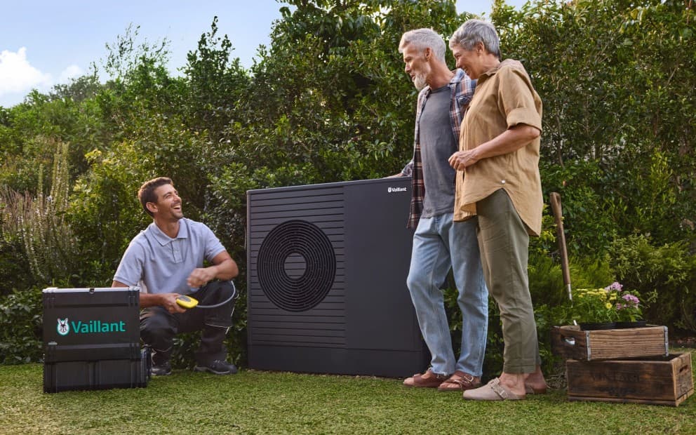 Tecnico Vaillant con clienti in giardino.